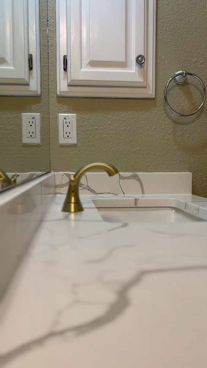 Vanity and fixture detail showing refined stone, hardware, and bathroom styling.
